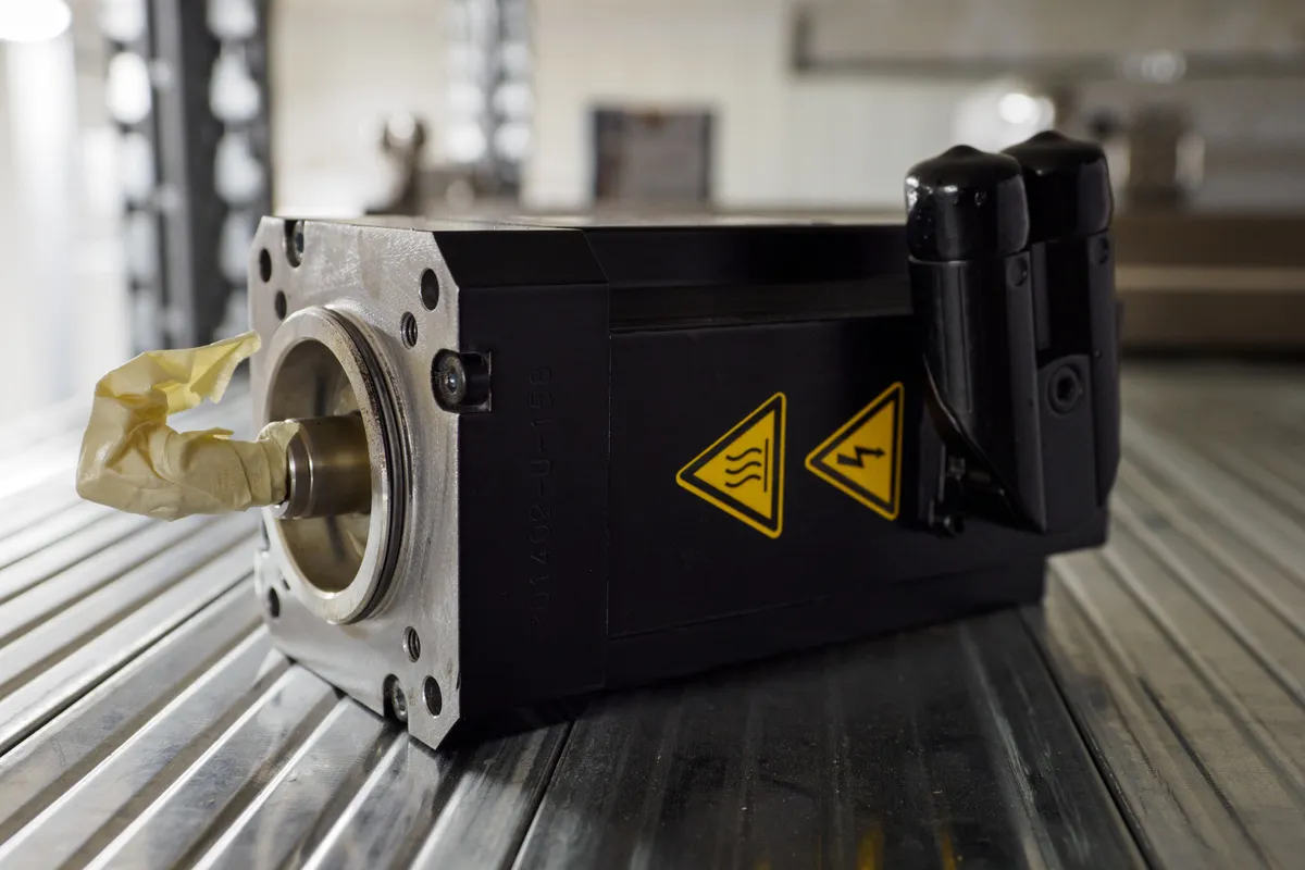SPSynergy UG - Automatisierungs- und Industrieelektronik – Ankauf, Verkauf und Demontage - Ein Ersatzservomotor liegt im Gestell.